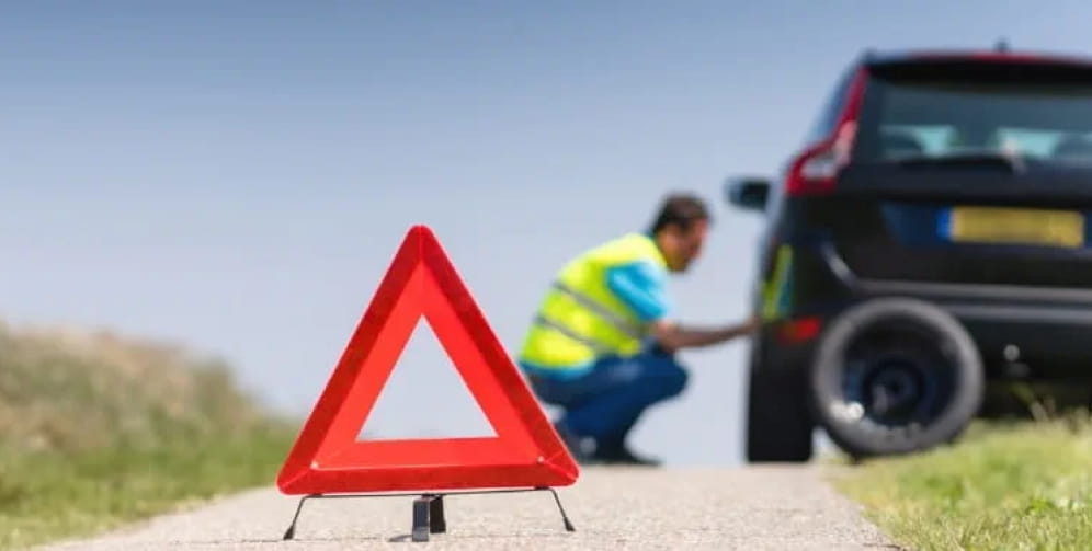 Man repairing a vehicle by the roadside