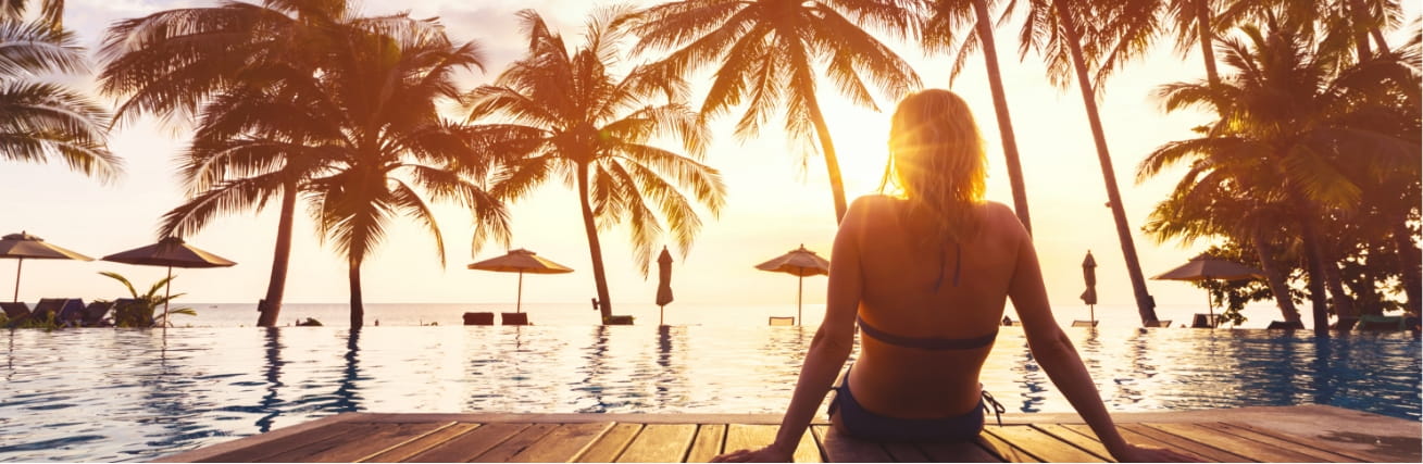 Women sitting on decking looking out to the sunset